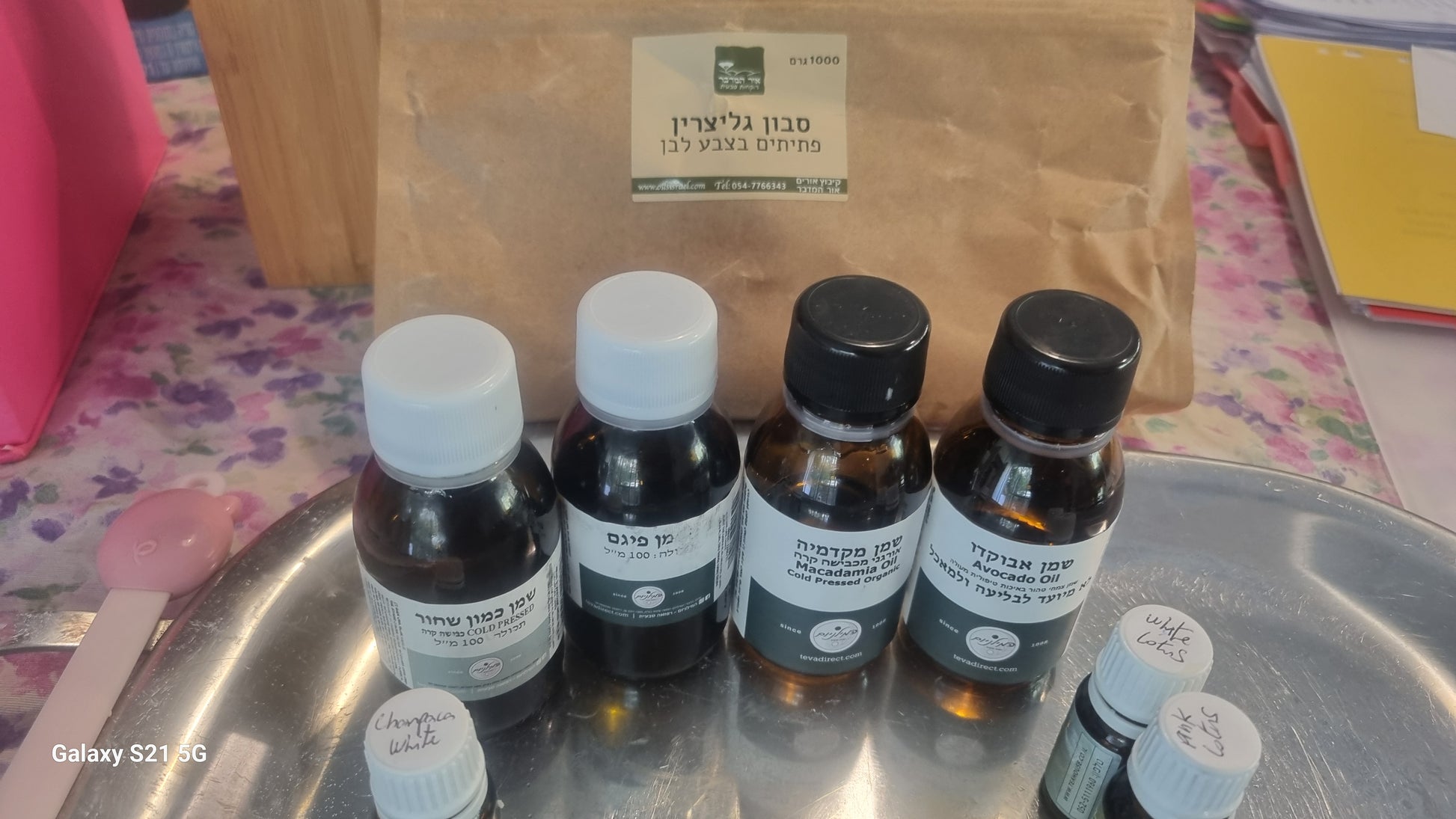 Set of small bottles with labels on a metal tray, with a brown paper bag in the background.