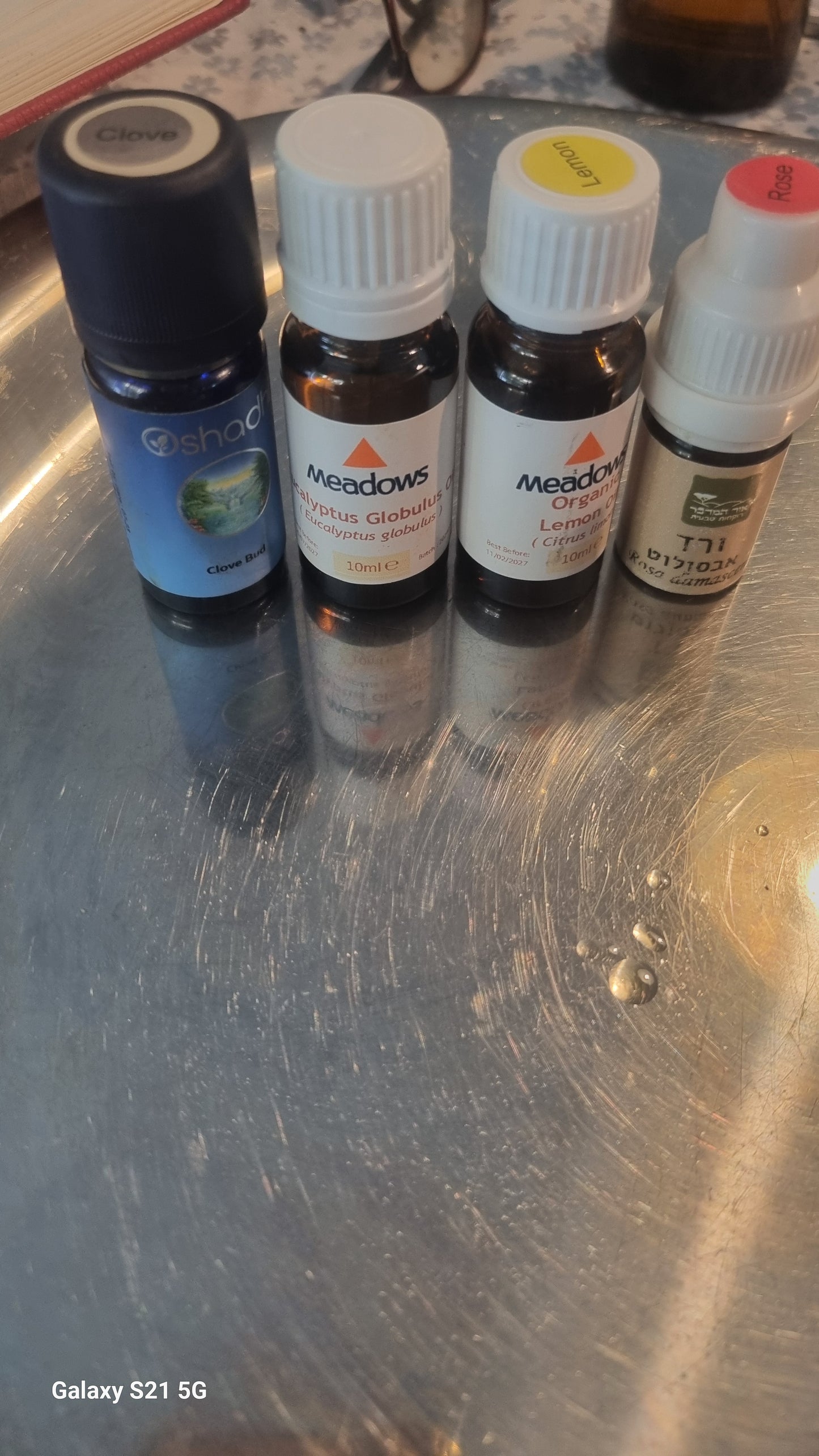 Collection of small bottles with colorful labels on a metallic surface