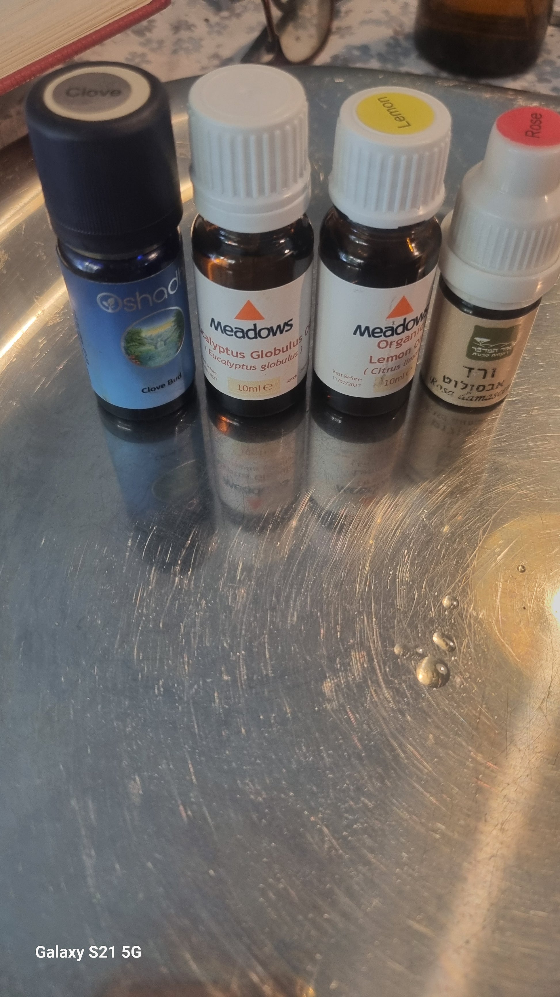 Collection of small bottles with colorful labels on a metallic surface