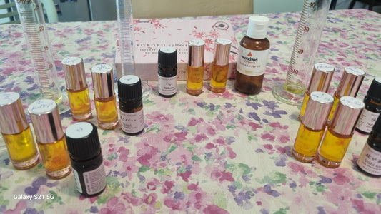 Collection of small bottles and containers on a floral tablecloth. Kokoro Collection