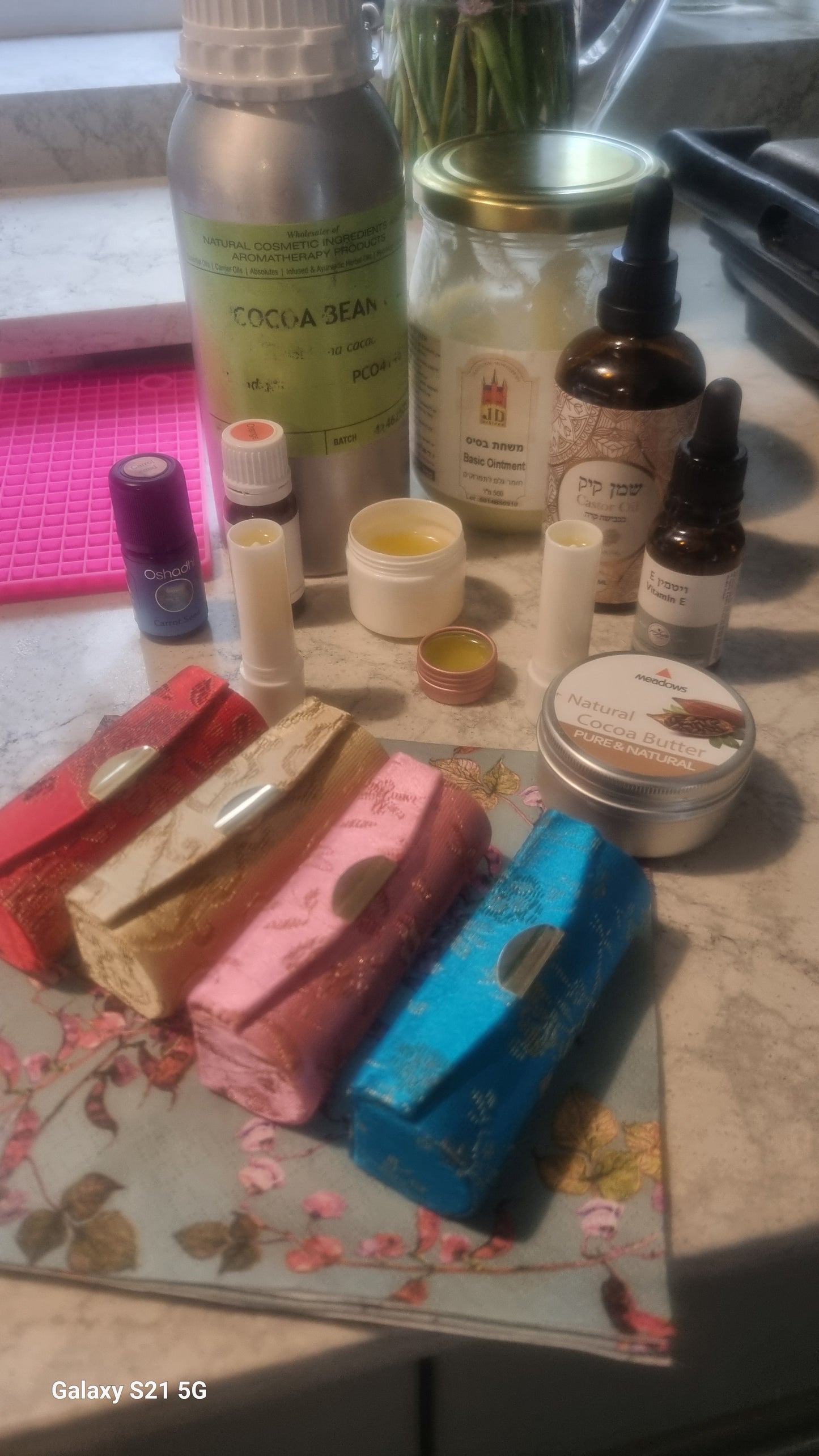 Collection of skincare and beauty products on a floral-patterned surface