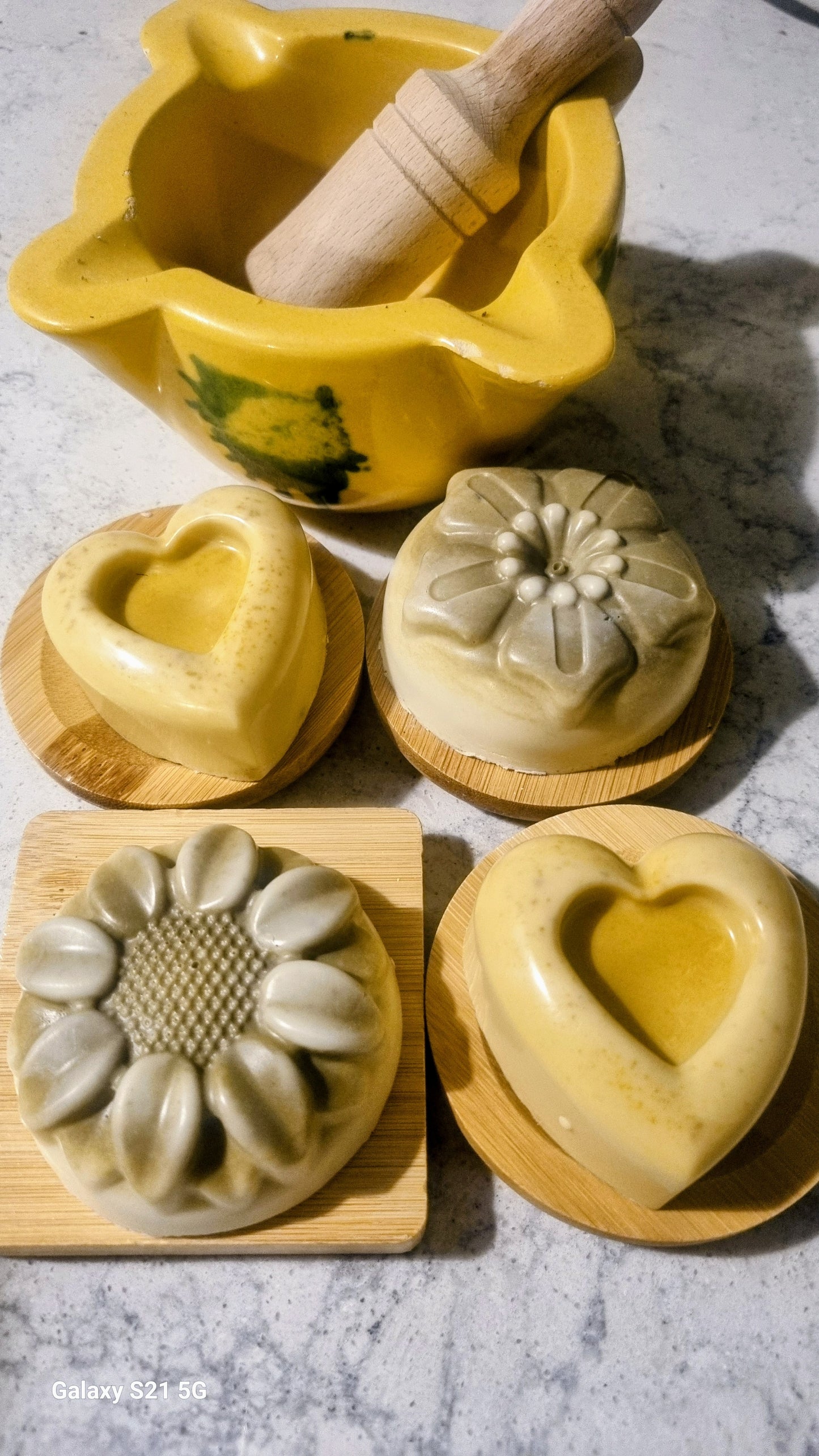 Set of handmade soap molds with wooden tools on a marble surface