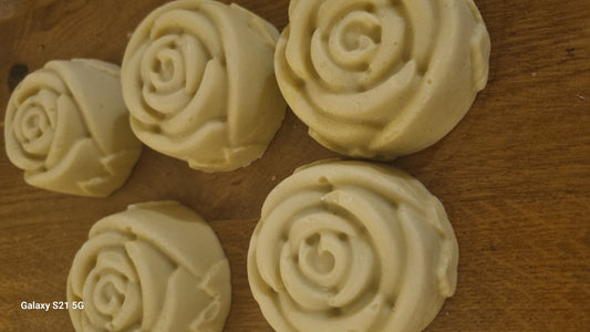 Rose-shaped soap pieces on a wooden surface
