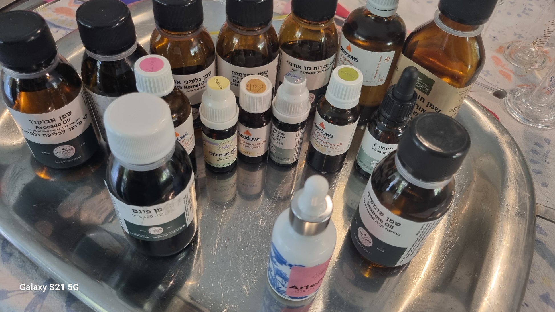 Collection of small bottles with various labels on a metallic tray.
