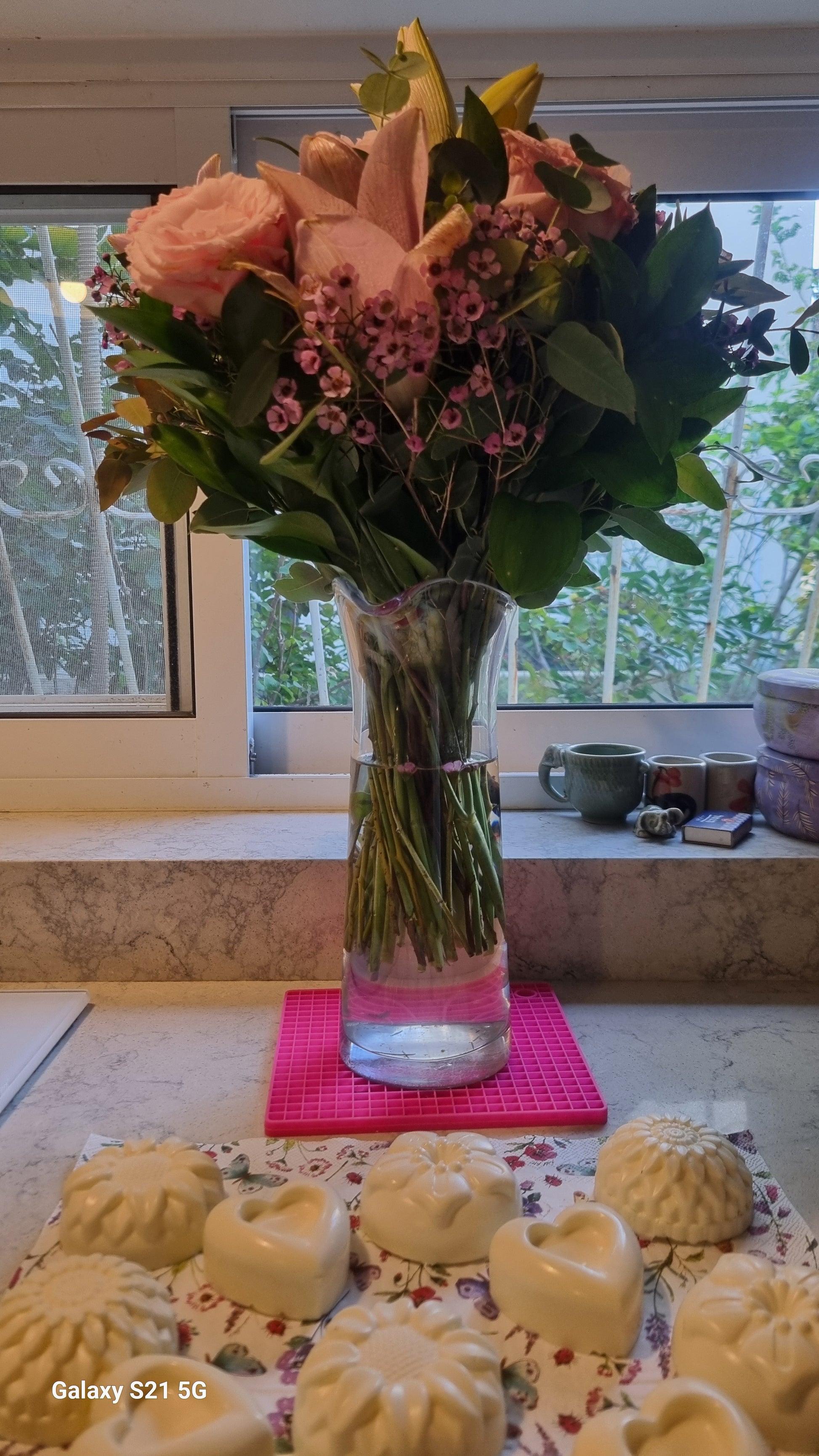 Bouquet of flowers in a vase on a table with a window in the background