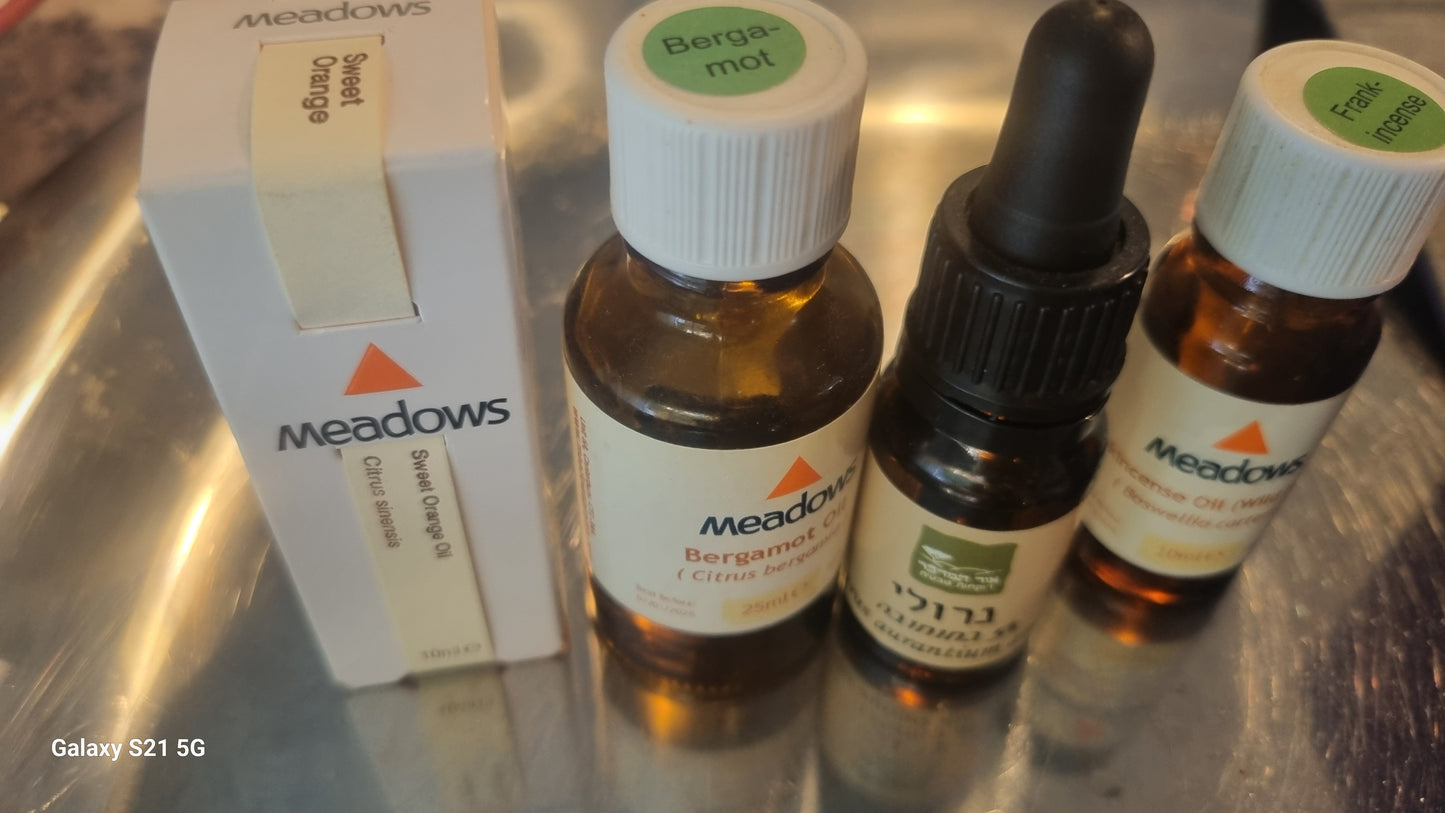 Meadows essential oil bottles and packaging on a reflective surface