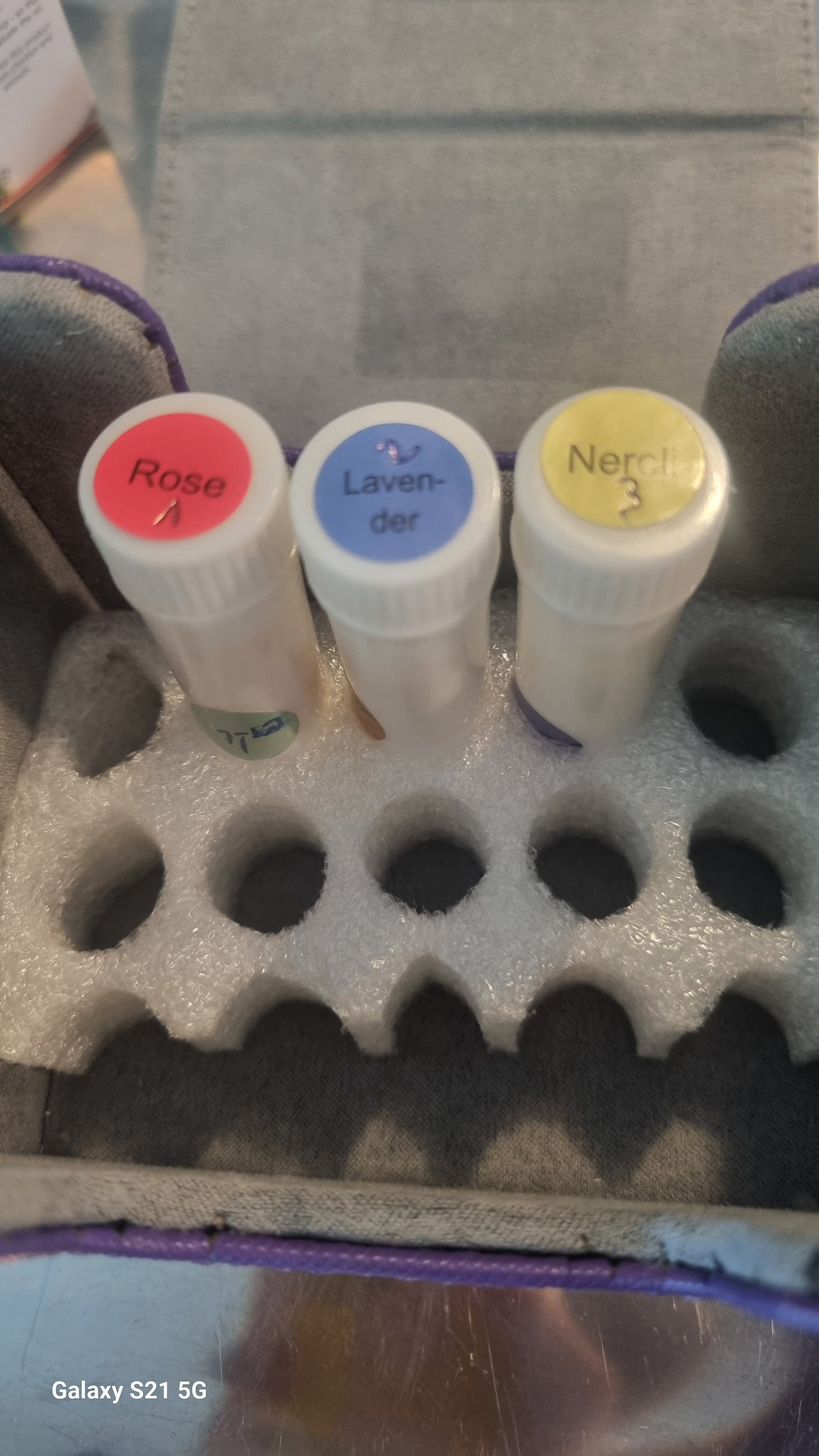 Three Inhalers with color labels on a foam block